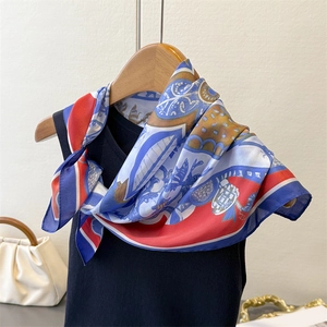Foulard in seta artistica con motivi geometrici drappeggiato su un top in maglia