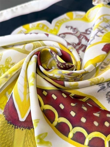 Dettaglio del foulard in raso con stampa retrò che mostra la texture setosa e il drappeggio
