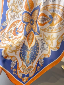 Dettaglio del foulard in seta con motivi barocchi e finiture con bordi arrotolati