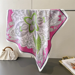 Dettaglio di un foulard quadrato in seta con motivi floreali su una borsa bianca