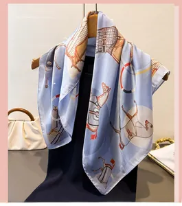 Detailed close-up of a light blue satin silk scarf with elegant equestrian horse patterns