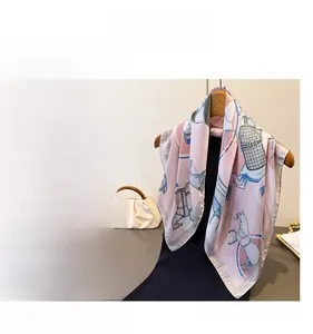 Detail of elegant horse print silk scarf featuring equestrian motifs in soft pink