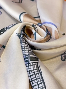 Macro shot of satin silk scarf featuring vintage horse prints with elegant glossy texture