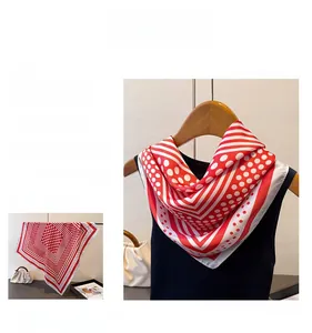 Close-up of red and white polka dot silk scarf featuring striped geometric border details