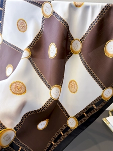 Detail of silk-feel checkerboard scarf featuring golden lion emblems and chain patterns