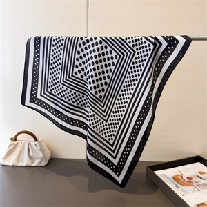 Detailed view of square silk scarf with black polka dots and geometric frame pattern