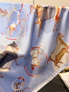 Detailed view of horse print silk scarf featuring premium satin texture and rolled edges