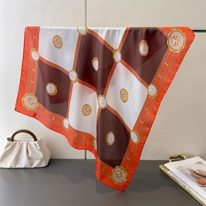 Macro detail of silk square scarf featuring checkerboard pattern and lion head relief