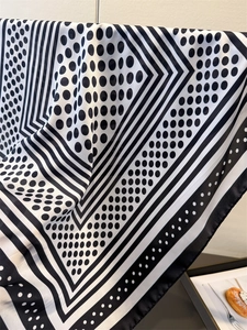 Detailed draping of silk-like scarf with black and white polka dots and stripes