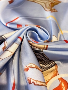 Detailed close-up showing the glossy texture and elegant equestrian horse print of silk scarf