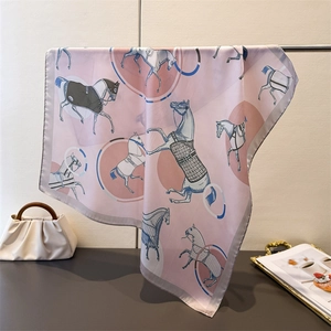 Detail of pink silk scarf with equestrian horse print hanging on a metal stand