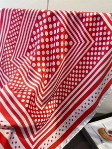 Close-up of red and white polka dot silk scarf with elegant geometric patterns