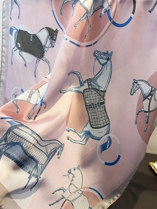 Detailed view of silk-like scarf featuring elegant equestrian horse and harness patterns