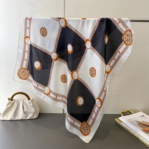 Detailed close-up of a silk square scarf with checkered pattern and golden chain border