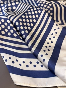 Close-up of blue and white polka dot silk scarf showing satin texture and neat edges