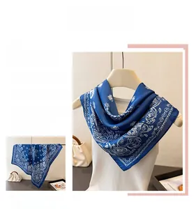 Detailed view of navy blue paisley silk scarf styled on model and flat lay arrangement