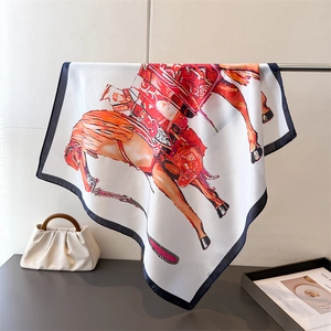 Detailed view of white silk scarf with equestrian horse prints and dark blue borders