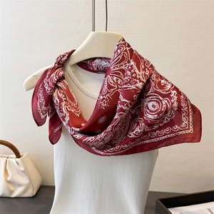 Detailed drape of burgundy faux silk scarf with white floral print on a model neck