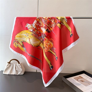 Detail of red silk scarf with equestrian horse print hanging next to a white bag