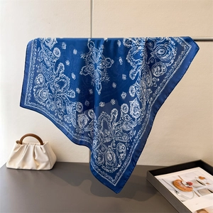 Detail of royal blue paisley silk scarf draped elegantly showing smooth satin texture