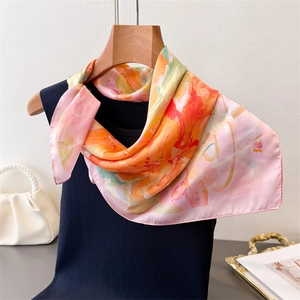 Detailed view of colorful abstract print silk scarf draped over a wooden hanger