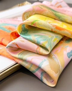 Close-up of marble pattern silk scarf with vibrant pink, green, and yellow textures