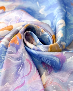 Close-up of silk scarf with colorful abstract marble print in blue and lilac purple
