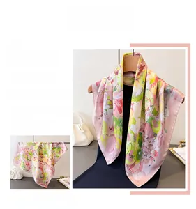 Detail view of pink and yellow printed faux silk square scarf with soft satin finish