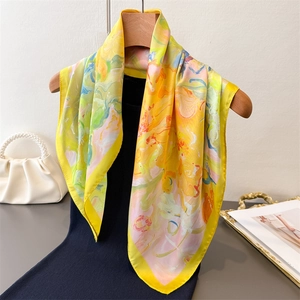 Vibrant lemon yellow abstract floral silk scarf styled with a black outfit and pearl bag