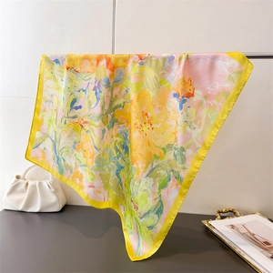 Detailed macro view of colorful floral pattern and yellow border on luxury silk scarf