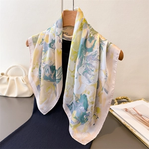 Elegant floral faux silk square scarf in yellow and green on a wooden hanger