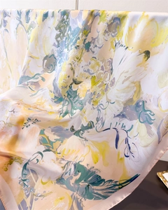 Detail of silk-like satin scarf featuring abstract floral prints and fine stitched edges