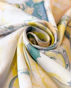 Detailed close-up of artistic watercolor silk scarf with smooth lustrous texture