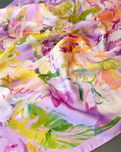 Detail of vibrant watercolor floral silk scarf showing smooth texture and draped folds