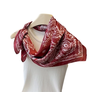 Elegant red silk scarf with white rose paisley print draped on a mannequin