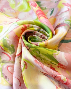 Macro shot of abstract floral print silk scarf with soft pink and yellow textures