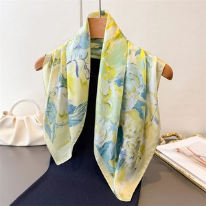 Elegant silk-like square scarf with yellow and green abstract art prints on wood hanger