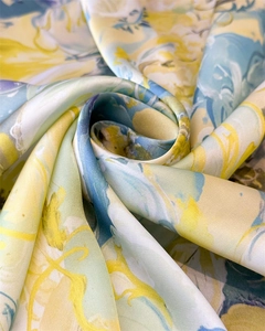 Macro shot of printed silk square scarf with floral pattern and smooth satin texture
