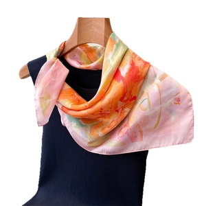 Artistic abstract watercolor print silk scarf tied on a dark blue vest for display