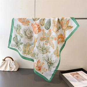 Detailed view of silk square scarf featuring elegant tulip patterns and green borders