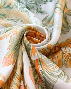 Detailed close-up of baroque floral satin scarf with orange and green leaf patterns