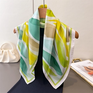 Élégant foulard en soie avec imprimé abstrait jaune et vert sur cintre en bois