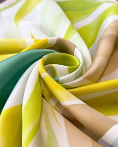 Gros plan du tissu d'un foulard en soie avec motifs ondulés et texture satinée lisse