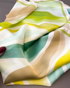 Gros plan sur la texture soyeuse du foulard avec motif abstrait en dégradé de couleurs