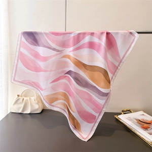 Détail du foulard en soie avec motifs de vagues dégradés roses et mauves et finitions soignées