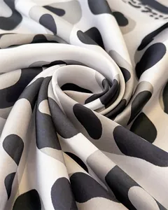 Macro shot of black and white animal print silk fabric with smooth texture and swirl drape