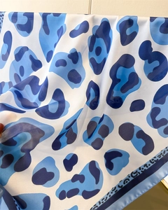 Macro detail of blue leopard print silk scarf showing soft texture and fine hemmed edges