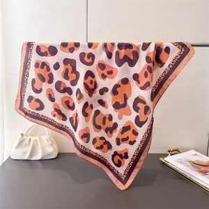 Detail of leopard print silk scarf draped over a stand showing soft fabric texture