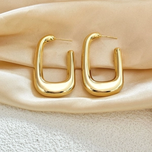 Thick hollow gold-plated U-shaped earrings on champagne silk background