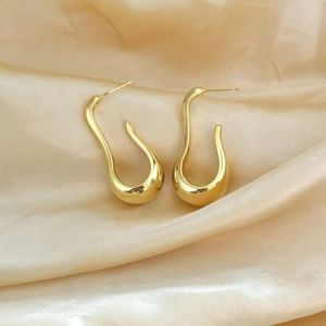 Chic gold-plated U-shaped teardrop earrings on elegant champagne satin backdrop